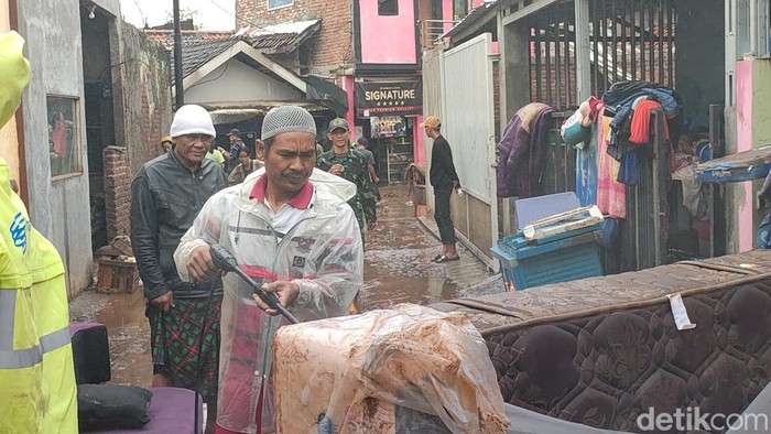 Warga Garut yang terdampak banjir bandang bergotong royon membersihkan rumah, Mereka dibantu oleh TNI-Polri dalam membersihkan sisa-sisa lumpur luapan Sungai Cimanuk