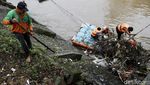 Gercep! Petugas Bersihkan Sampah Kayu di Pintu Air Manggarai