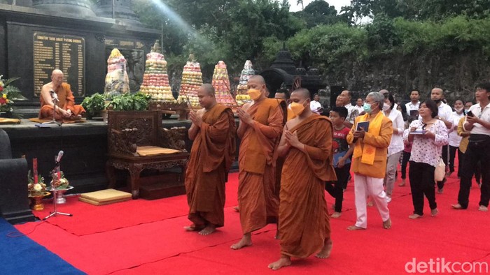 Para umat Buddha mengelilingi Candi Sudhammo MahaThera di Kompleks Vihara Ratanavana Arama, salah satu rangkaian kegiatan peringatan Hari Raya Suci Maha Puja Asadha, pada Minggu (17/7/2022) sore.