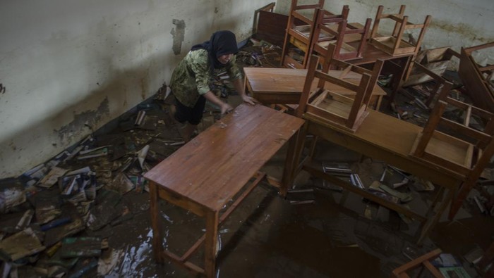 Dua orang warga membersihkan ruangan kelas yang terendam lumpur akibat banjir bandang Sungai Cimanuk di Sekolah PGRI Garut, Jawa Barat, Sabtu (16/7/2022). Banjir bandang akibat luapan Sungai Cimanuk saat intensitas curah hujan yang tinggi pada Jumat (15/7) kemarin mengakibatkan sejumlah sekolah hingga rumah ibadah rusak berat. ANTARA FOTO/Novrian Arbi/wsj.
