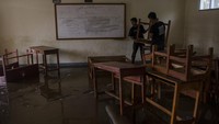 Dua orang warga membersihkan ruangan kelas yang terendam lumpur akibat banjir bandang Sungai Cimanuk di Sekolah PGRI Garut, Jawa Barat, Sabtu (16/7/2022).