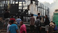 Warga mengamati bangkai kapal kargo yang terbakar di Pelabuhan Kalimas Surabaya, Jawa Timur, Minggu (17/7/2022).
