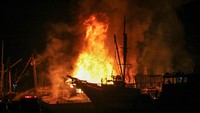 Api membakar kapal kargo yang bersandar di Pelabuhan Kalimas Surabaya, Jawa Timur, Minggu (17/7/2022).