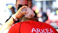 Pebalap Hugo Hofstetter memasukkan es balok ke dalam bajunya pada etape 15 TDF 2022, Minggu (17/7/2022). (Tim de Waele/Getty Images)
