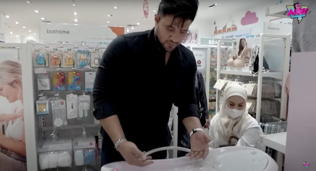 Irish dan Ammar Zoni tampak kompak melihat-lihat dan memilih barang apa saja yang akan dibelinya untuk sang buah hati. Seperti dalam foto, keduanya tampak serius memilih bak mandi untuk anak keduanya itu. Foto: YouTube/Aish TV