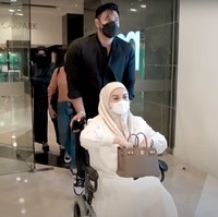 Melalui salah satu unggahan video di channel YouTube miliknya, Irish Bella dan Ammar Zoni tampak membagikan keseruan mereka ketika belanja keperluan bayi jelang kelahiran anak kedua. Sedaang hamil besar, Irish pun tampak didorong menggunakan kursi roda oleh sang suami. Foto: YouTube/Aish TV