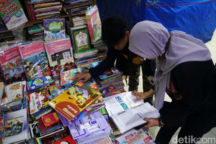 Sejumlah orang tua mencari buku pelajaran anak sekolah di sentra buku bekas Blok M Square, Jakarta, Senin (18/7/2022). Sentra buku bekas ini bisa menjadi alternatif orang tua dalam mencari buku sekolah anak.