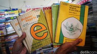 Pedagang menunjukkan beberapa buku bekas yang dijualnya.