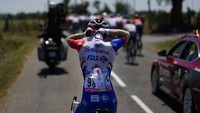Pebalap Michael Storer memasukkan cadangan botol minum ke dalam baju jersey saat balapan etape 15 TDF 2022, Minggu (17/7/2022). Baju yang lentur dan elastis sanggup mengantongi lebih dari 5 botol minum atau bidon. (AP Photo/Thibault Camus)