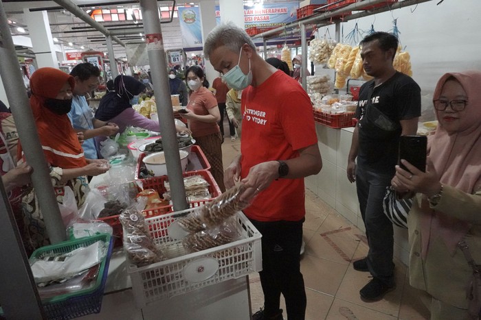 GANJAR PANTAU HARGA SEMBAKO DI BANYUMAS Gubernur Jateng Ganjar Pranowo (ketiga) kiri menyapa warga saat blusukan di Pasar Manis Purwokerto, Banyumas, Jateng, Senin (18/7/2022). Ganjar melakukan blusukan di Pasar Manis saat melakukan kunjungan kerja di Kabupaten Banyumas, untuk memantau fluktuasi harga bahan pokok dalam upaya pengendalian inflasi di Jawa Tengah. ANTARA FOTO/Idhad Zakaria/hp.