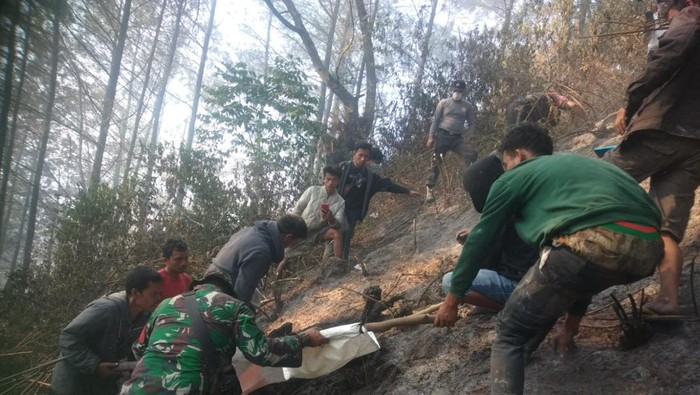 Tim gabungan TNI Polri mengevakuasi korban dari kawasan hutan yang terbakar di Kecamatan Muara, Taput, Minggu (17/7/2022). Dokumen Humas Polres Taput