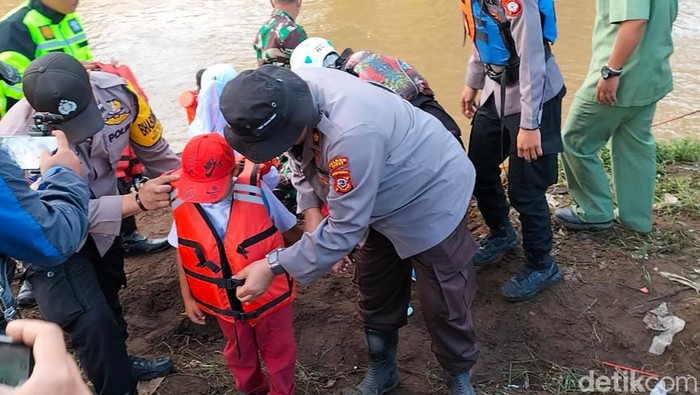 Jembatan terputus akibat banjir bandang membuat siswa SD di Garut menyebrang dengan menggunakan perahu karet