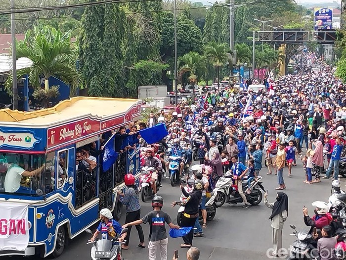 Pemain Arema FC disambut dan dikawal aremania