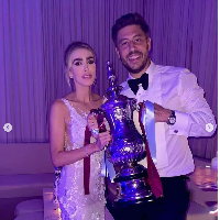 Petra Ecclestone dan Sam Palmer berpose memegang hadiah pernikahan mereka, yaitu Piala FA 1980 yang dimenangkan West Ham setelah mengalahkan Arsenal. Foto: Dok. Instagram Petra Ecclestone
