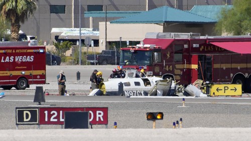 Officials investigate the wreckage of a plane at the site of a fatal crash at the North Las Vegas Airport, Sunday, July 17, 2022, in North Las Vegas, Nev. Authorities say several people are dead after two small planes collided at North Las Vegas Airport. (AP Photo/John Locher)