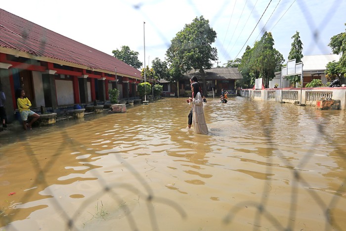 SEKOLAH TERDAMPAK BANJIR Seorang anak bermain air saat banjir menggenangi SDN 02 Pranggong, Kecamatan Arahan, Indramayu, Jawa Barat, Senin (18/7/2022). Pihak sekolah terpaksa meliburkan siswanya pada hari pertama masuk sekolah karena sejumlah ruang kelas terendam banjir akibat luapan sungai Cipelang. ANTARA FOTO/Dedhez Anggara/hp.