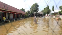 Anak-anak bermain di halaman sekolah yang tergenang banjir di SDN 02 Pranggong, Kecamatan Arahan, Indramayu, Jawa Barat, Senin (18/7/2022).