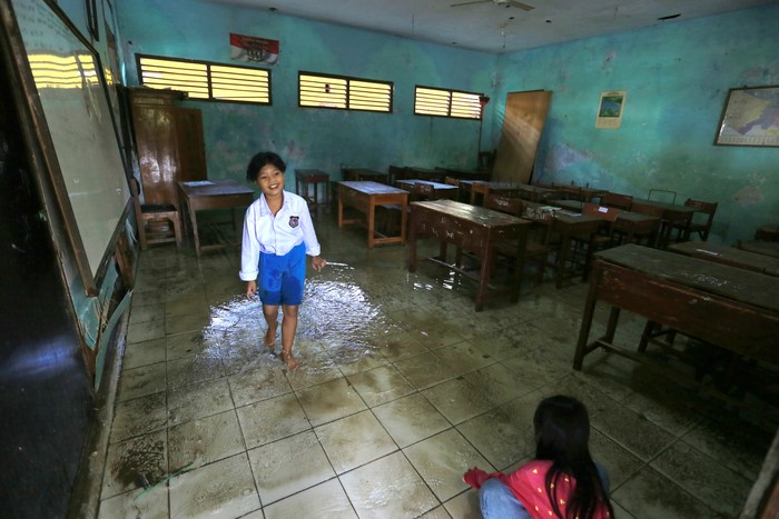 SEKOLAH TERDAMPAK BANJIR Seorang anak bermain air saat banjir menggenangi SDN 02 Pranggong, Kecamatan Arahan, Indramayu, Jawa Barat, Senin (18/7/2022). Pihak sekolah terpaksa meliburkan siswanya pada hari pertama masuk sekolah karena sejumlah ruang kelas terendam banjir akibat luapan sungai Cipelang. ANTARA FOTO/Dedhez Anggara/hp.