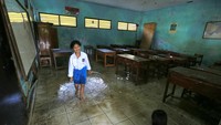 Siswa melihat kondisi kelas yang tergenang banjir di di SDN 02 Pranggong, Kecamatan Arahan, Indramayu, Jawa Barat, Senin (18/7/2022). Akibat banjir ini, aktifitas belajar mengajar di hari pertama tahun ajaran baru diliburkan.