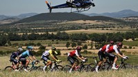 Helikopter yang membawa kamera televisi merekam rombongan pebalap pada etape 14 TDF 2022, Prancis, Minggu (17/7/2022). (Marco Bertorello/AFP/Getty Images)