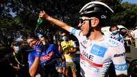 Tadej Pogacar (kanan) menyiram air kepada pemenang etape 15, Jasper Philippsen, pada etape 15 TDF 2022, Prancis, Minggu (17/7/2022). Suhu panas membuat para pebalap selalu membasahi tubuh menggunakan air atau es balok. (Tim de Waele/Getty Images)