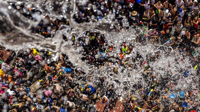People throw water at each other during the annual water fight in the streets of the Vallecas neighborhood of Madrid, Spain, Sunday, July 17, 2022. (AP Photo/Manu Fernandez)