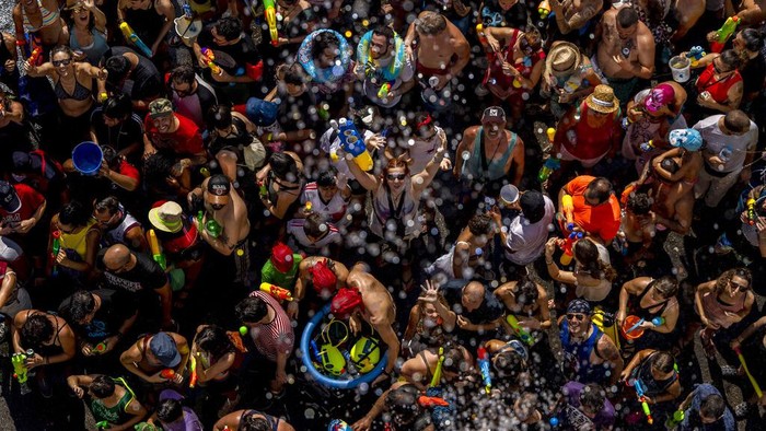People throw water at each other during the annual water fight in the streets of the Vallecas neighborhood of Madrid, Spain, Sunday, July 17, 2022. (AP Photo/Manu Fernandez)