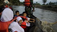 Anak-anak melintas menggunakan perahu karet dan rompi keselamatan. Rusaknya jembatan penghubung antar kecamatan ini merupakan dampak dari banjir bandang Sungai Cimanuk beberapa waktu lalu.   