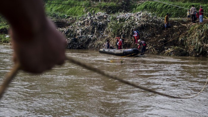 Tim SAR gabungan membantu pelajar turun dari perahu karet setelah menyeberangi Sungai Cimanuk, Garut, Jawa Barat, Selasa (19/7/2022). Warga di kawasan tersebut terpaksa menggunakan perahu karet yang disediakan oleh Tim SAR gabungan Polri, TNI dan Badan Penanggulangan Bencana Daerah (BPBD) Garut untuk akses penyeberangan, khususnya untuk menuju sekolah setelah jembatan penghubung antarkecamatan dampak banjir bandang Sungai Cimanuk beberapa waktu lalu. ANTARA FOTO/Novrian Arbi/rwa.