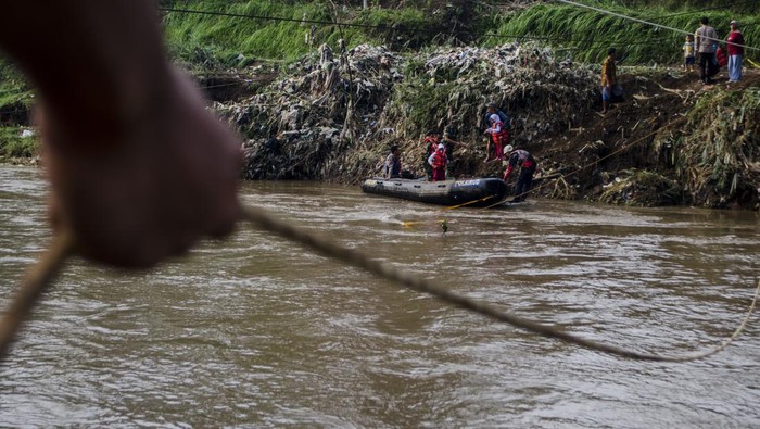 AKSES PENYEBERANGAN WARGA TERDAMPAK BANJIR BANDANG GARUT Tim SAR gabungan membantu pelajar turun dari perahu karet setelah menyeberangi Sungai Cimanuk, Garut, Jawa Barat, Selasa (19/7/2022). Warga di kawasan tersebut terpaksa menggunakan perahu karet yang disediakan oleh Tim SAR gabungan Polri, TNI dan Badan Penanggulangan Bencana Daerah (BPBD) Garut untuk akses penyeberangan, khususnya untuk menuju sekolah setelah jembatan penghubung antarkecamatan dampak banjir bandang Sungai Cimanuk beberapa waktu lalu. ANTARA FOTO/Novrian Arbi/rwa.