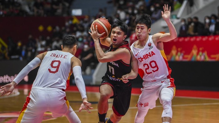 Pebasket Indonesia Yudha Saputera (tengah) mencoba melewati hadangan pebasket tim nasional basket China pada babak playoff FIBA Asia Cup 2022 di Istora Gelora Bung Karno, Senayan, Jakarta, Senin (18/7/2022). China mengalahkan Indonesia dengan skor 108-58. ANTARA FOTO/Galih Pradipta/tom.