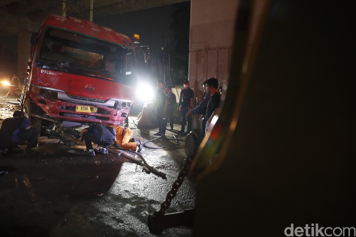 Petugas gabungan kepolisian dan Pemadam Kebakaran berjibaku mengevakuasi Truk Pertamina di lokasi kecelakaan maut Cibubur.