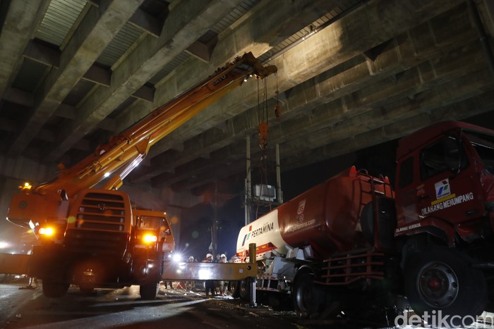 Petugas gabungan kepolisian dan Pemadam Kebakaran berjibaku mengevakuasi Truk Pertamina di lokasi kecelakaan maut Cibubur.