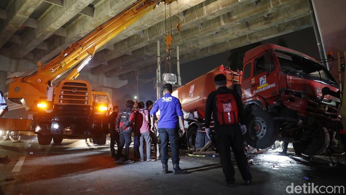 Foto-foto Evakuasi Truk Maut Pertamina Petugas gabungan kepolisian dan Pemadam Kebakaran berjibaku mengevakuasi Truk Pertamina di lokasi kecelakaan maut Cibubur.