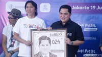 Bimbim dan Erick Thohir memamerkan karikatur dengan nomor 024 yang jadi simbolis nomor koperasi. Foto: Noel/detikhot