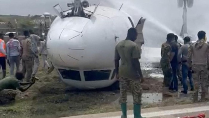SOMALIA-PLANE/ Firefighters spray water on a plane that flipped over after a crash landing, in Mogadishu, July 18, 2022, in this screen grab obtained from a social media video obtained by Reuters. THIS IMAGE HAS BEEN SUPPLIED BY A THIRD PARTY NO RESALES. NO ARCHIVES
