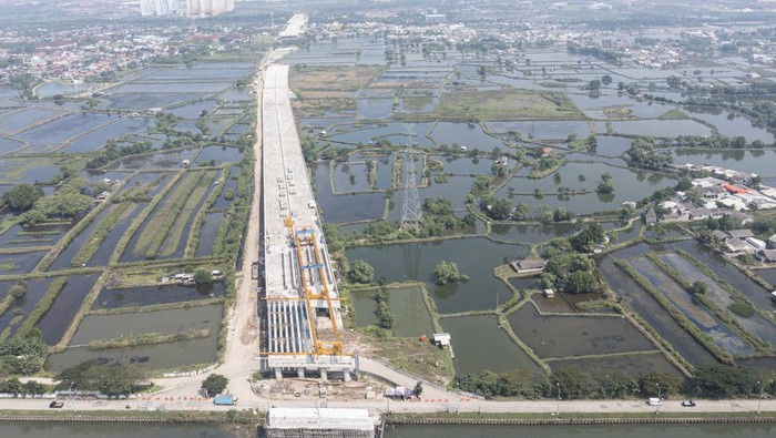 Tol Cibitung-Cilincing Seksi 4 Dibangun Membentang di Tengah Persawahan Foto udara proyek pembangunan Jalan Tol Cibitung-Cilincing (JTCC) seksi 4 di Marunda, Cilincing, Jakarta Utara, Selasa (19/7/2022). Kementerian Pekerjaan Umum dan Perumahan Rakyat (PUPR) bersama Badan Usaha Jalan Tol (BUJT) berupaya menyelesaikan ruas Tol Cibitung-Cilincing sepanjang 34,77 kilometer tersebut yang merupakan salah satu Proyek Strategis Nasional (PSN) dan progresnya mencapai 71,79 persen. ANTARA FOTO/M Risyal Hidayat/rwa.