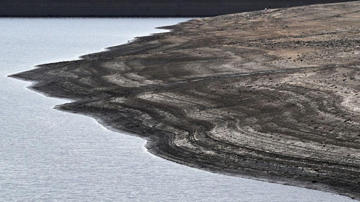 Waduk di Inggris Surut Dihantam Gelombang Panas The dry, cracked bed of Baitings Reservoir, revealed by the falling water level, is pictured west of Ripponden, in northern England on July 17, 2022. - The UK's meteorological agency on Friday issued its first ever