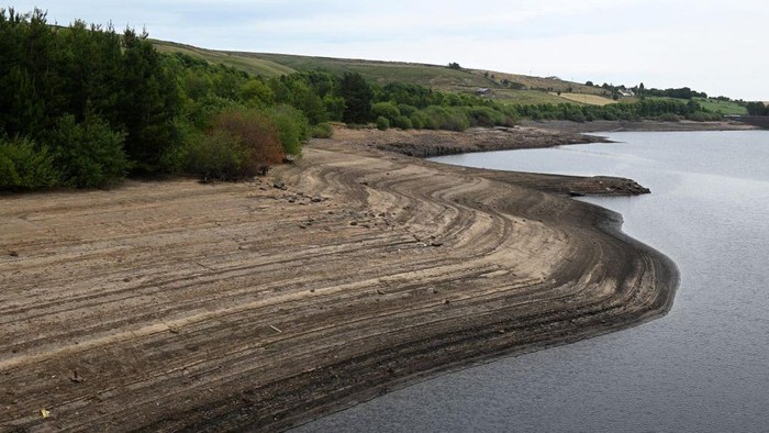 Waduk di Inggris Surut Dihantam Gelombang Panas The dry, cracked bed of Baitings Reservoir, revealed by the falling water level, is pictured west of Ripponden, in northern England on July 17, 2022. - The UK's meteorological agency on Friday issued its first ever