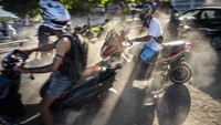 Orang-orang berkumpul di motor listrik mereka untuk menghabiskan sore hari sembari memamerkan aksi dan balap di Havana, Kuba, Jumat (15/7/2022).