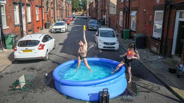 LEEDS, UNITED KINGDOM - JULY 19: A family enjoy a barbecue and cool off in apaddling pool outside their home on July 19, 2022 in Leeds, United Kingdom. Temperatures exceeded 40C in parts of England today after the Met Office issued its first red extreme heat warning.  Record-breaking temperatures were reached across the UK.  (Photo by Christopher Furlong/Getty Images)