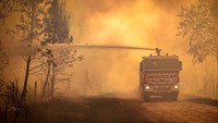 Truk pemadam kebakaran menyemprotkan cairan pada kebakaran hutan di Landiras, Prancis barat daya, 14 Juli 2022. Suhu tinggi dan angin kencang telah mempersulit upaya pemadaman kebakaran di wilayah tersebut. (SDIS 33/AP Photo)