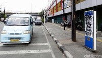 Coretan menutup peta informasi rute bus. Akibatnya warga tidak bisa membaca informasi di papan tersebut.