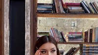 Minum avocado dengan es krim di atasnya. Monna berpose di kafe dengan konsep vintage yang memiliki banyak buku-buku. Foto: Instagram @monnafrans