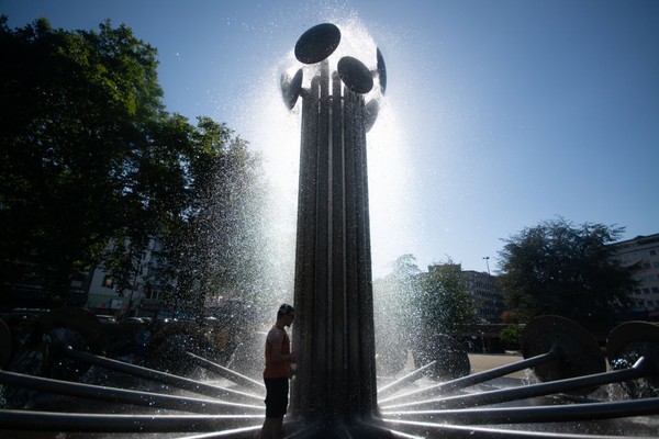 Gelombang panas di Jerman membuat suhu naik sampai 39 derajat celcius. Di Kota Cologne, warga terlihat main basah-basahan di bawah air mancur. (Getty Images)