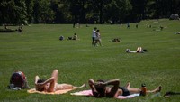 Orang-orang berbaring di Sheep Meadow di Central Park di New York City pada 19 Juli 2022, saat gelombang panas berlanjut ke seluruh Eropa dan Amerika Utara. (Getty Images)