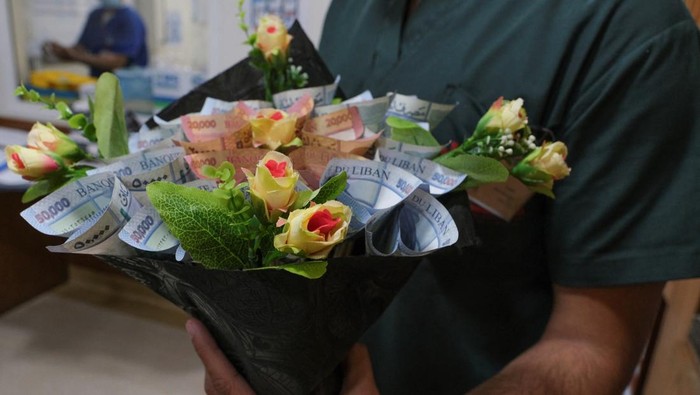 Mohamad Farah works on preparing a bouquet made out of Lebanese pound banknotes at a shop in a suburb of Beirut, Lebanon July 13, 2022. REUTERS/Emilie Madi