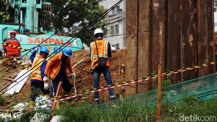 Sejumlah pekerja tengah melakukan pekerjaan di lokasi semburan gas di kawasan Cawang, Jakarta, Rabu (20/7/2022). Semburan gas terjadi akibat pemasangan tiang pancang pembangunan halte integrasi TransJakarta, KRL, dan LRT di kawasan Cawang.