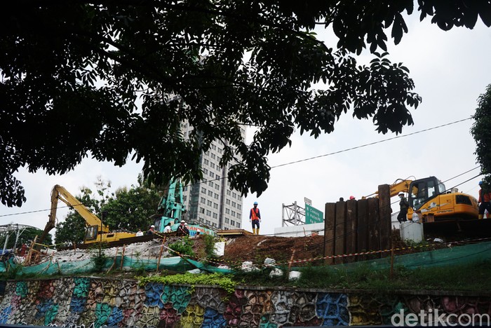 Sejumlah pekerja tengah melakukan pekerjaan di lokasi semburan gas di kawasan Cawang, Jakarta, Rabu (20/7/2022). Semburan gas terjadi akibat pemasangan tiang pancang pembangunan halte integrasi TransJakarta, KRL, dan LRT di kawasan Cawang.