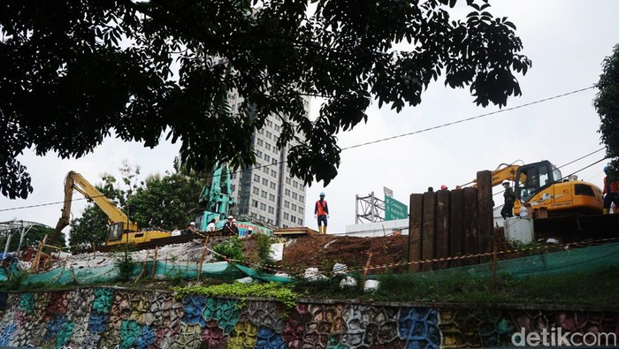 Sejumlah pekerja tengah melakukan pekerjaan di lokasi semburan gas di kawasan Cawang, Jakarta, Rabu (20/7/2022). Semburan gas terjadi akibat pemasangan tiang pancang pembangunan halte integrasi TransJakarta, KRL, dan LRT di kawasan Cawang.